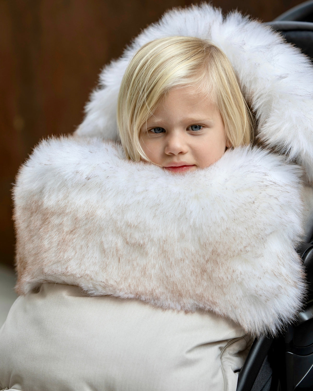 a blond baby in a footmuff