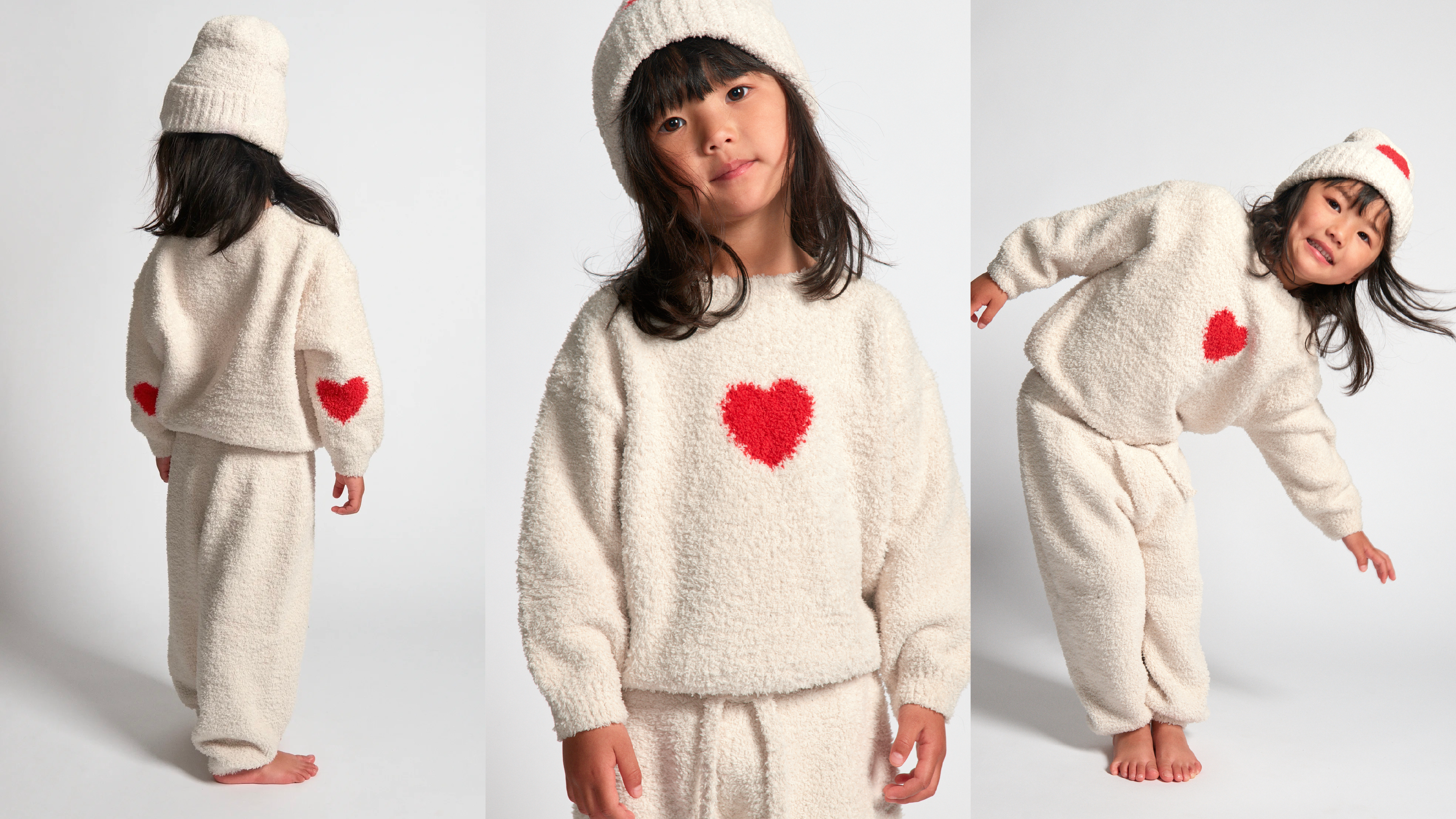 3 girls wearing a fuzzy white sweater and beanie with hearts on it.